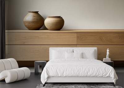 Closeup of a minimalist modern sideboard with vintage ceramic vases in neutral tones illuminated by natural light Wall mural