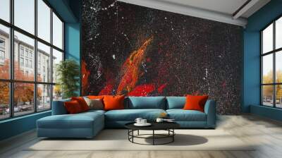 Red smears of orange paint on a black background Wall mural