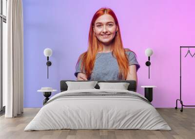 The redhead crosses her arms and smiles Wall mural