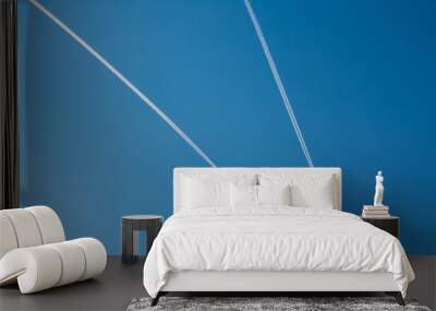 Two planes with traces on a blue sky background. Wall mural