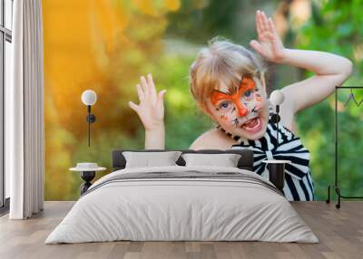 Portrait of funny girl with face painting on blurred background Wall mural