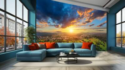 Aerial panorama of a vast landscape with a small town at a gorgeous colorful sunset with dramatic sky Wall mural