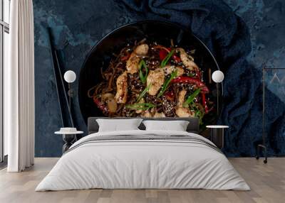 Asian wok noodles with chicken and vegetables with chopsticks on the table. Wall mural