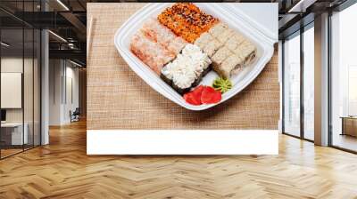 Two cTwo chopsticks, sushi and rolls in disposable packaging on wicker light background hopsticks, sushi and rolls in disposable packaging on wicker light background Wall mural