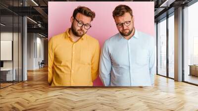 Disappointed business partners in casual attire reflecting on their challenges Wall mural