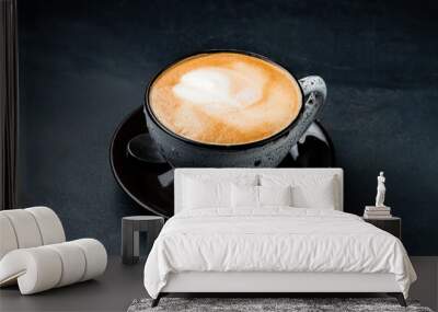 A cup of hot cappuccino coffee on black background. Wall mural