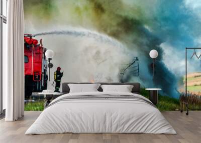 firefighter extinguishes a burning car after an accident Wall mural