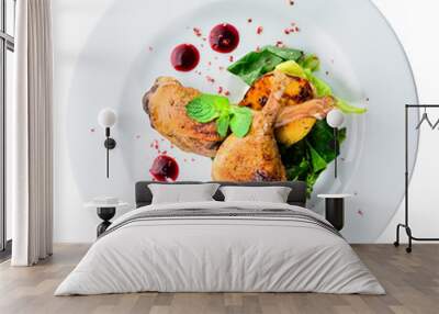 Juicy delicious cooked duck legs served with herbs and sauce in a white plate isolated on black background. Autumn menu in an Italian restaurant. Top view, flat, overhead Wall mural