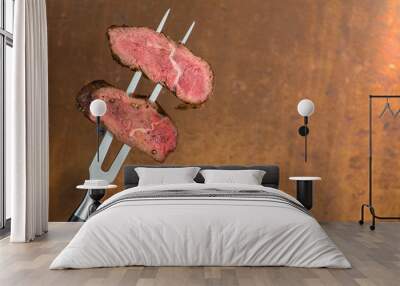 sliced steaks impaled on meat fork Wall mural