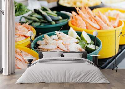 Fresh shrimp and seafood display at an outdoor market with lime and green herbs Wall mural