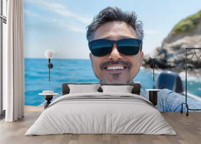 Smiling man enjoying a sunny day on the ocean with sunglasses and casual outfit Wall mural