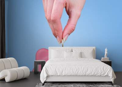 Female hand putting a coin in a piggy bank Wall mural