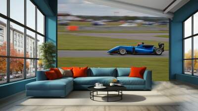 A panning shot of a racing car as it circuits a track. Wall mural