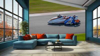 A panning shot of a racing sidecar as it corners on a track. Wall mural