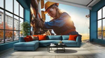 A protected female worker carries out repair tasks at a marine deposit as the sun sets,copy space Wall mural