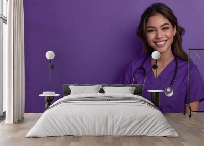 A young, cheerful Latina nurse wearing a purple medical gown and holding a stethoscope, standing in front of a purple background. Wall mural