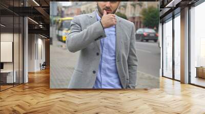 Portrait of a businessman on the street near the road of a European city. A bearded handsome man dressed stylishly. Fashionable guy hipster. Stock photos Wall mural