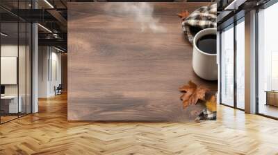 Wooden desk adorned with a steaming mug plaid blanket and scattered autumn leaves background with empty space for text Wall mural