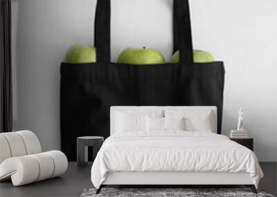 Black tote bag mockup with fruit on a white table. Wall mural