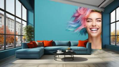 Young beautiful smiling happy woman with rainbow colored wavy hair isolated on flat blue background with copy space, banner template of Creative hair coloring. Wall mural