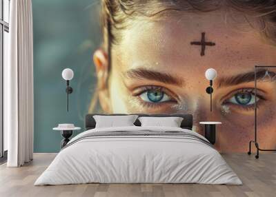 Young Woman with Ashen Cross, copy space, portrait. Close-up of a female face with an ashen cross on her forehead, Ash Wednesday. Wall mural