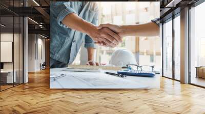 Architect and engineer construction workers shaking hands after success collaboration Wall mural