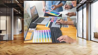 graphic designer team working on web design using color swatches editing artwork using tablet and a stylus At Desks In Busy Creative Office. Wall mural