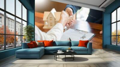 House developers agent or financial advisor and customers shaking hands after signing document making deal as successful agreement, contract with a firm. Wall mural