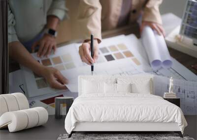 Two female architects discuss and brainstorm about interior designing building project on blueprint Wall mural