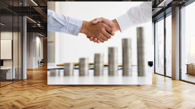 two people shake hand with stacked of coin on wood table concept as cooperate and teamwork to success in business and financial. Wall mural