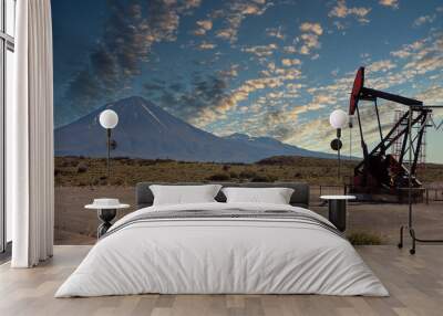 Oil pumps at large oilfield over mountain range. Wall mural