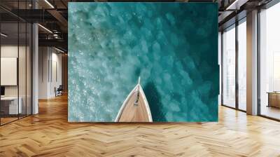 The bow of a yacht sailing in crystal blue waters. The yacht's design is elegant, with striped cushions and wooden details that contrast with the deep blue sea background. Wall mural