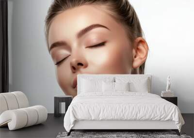 A beautiful woman face with closed eyes and smooth skin on white background Wall mural