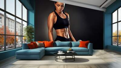 Beautiful fitness woman lifting dumbbells . Fitness sporty woman showing her well trained body . A beautiful girl's body with rippling muscles from strength training .  Wall mural