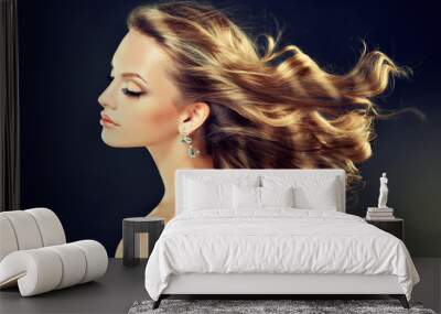 Beautiful model blond with curly hair and fashion earings Wall mural