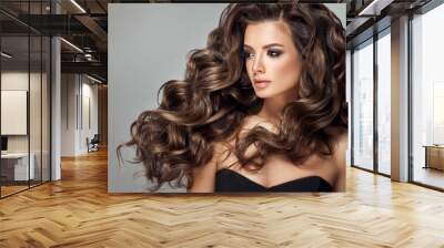 Beautiful model girl with long wavy and shiny hair . Brunette woman with curly hairstyle Wall mural