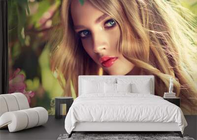 Beautiful spring   model girl   in flowers  in summer blossom park. Woman in a blooming garden . Fashion, Cosmetics & Perfumes . Curly blonde hair

 Wall mural