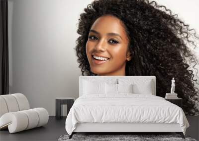 Beauty portrait of african american girl with clean healthy skin on beige background. Smiling dreamy beautiful black woman.Curly  hair in afro style  Wall mural