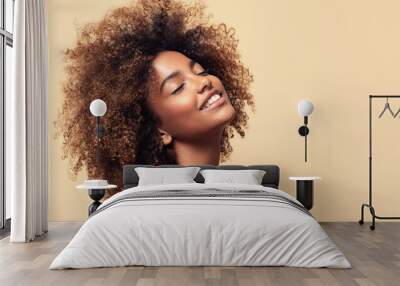 Beauty portrait of african american girl with clean healthy skin on beige background. Smiling dreamy beautiful black woman.Curly  hair in afro style  Wall mural