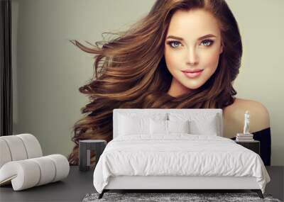 Brunette  girl with long  and   shiny wavy hair .  Beautiful  model with curly hairstyle .
 Wall mural