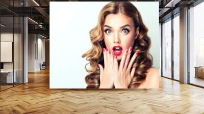 woman surprise showing product .beautiful girl with curly hair pointing to the side . presenting you Wall mural