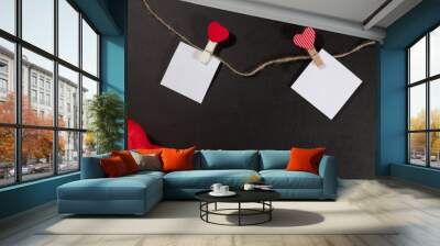 Two paper stickers attached with clothespins on a rope and hand made heart makes. valentines day black background. Wall mural