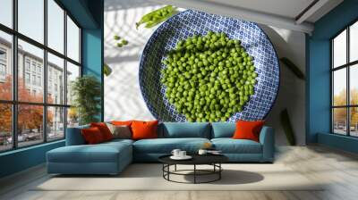 Fresh green pea in blue and white plate on white background Wall mural