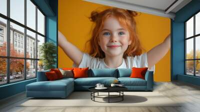 Cheerful girl with red hair smiling against yellow background Wall mural