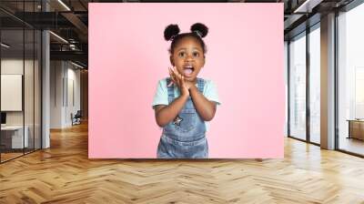 Children, emotions, gestures concept. Close up studio shot of pretty cute little African girl, scared, surprised or excited, posing to camera with her mouth open on isolated pink background Wall mural