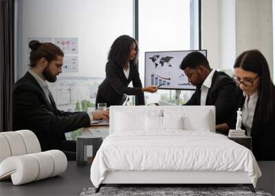 Diverse team in business meeting analyzing financial charts on laptop and screen. Professional environment with colleagues collaborating. Urban cityscape visible through large windows in background. Wall mural