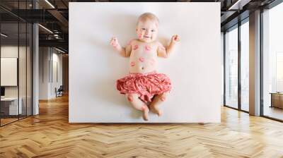 Image of adorable child with red kisses on the skin, happy baby girl isolated on white background, little love angel, romantic holiday, Valentines day concept Wall mural