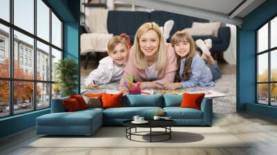 little sister, brother and their mother playing on warm floor with underfloor heating in living room Wall mural