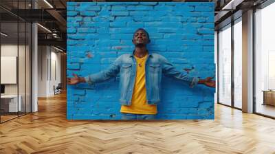 Man expressing freedom against vibrant blue brick wall outdoors Wall mural