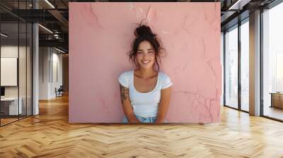 Natural beauty smiling against pink wall in casual attire Wall mural